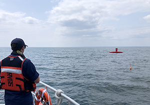 Coast Survey personnel observing an uncrewed surface vehicle in operation