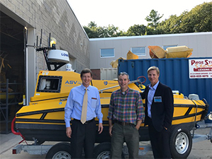 Thomas Chance (CEO of ASV Global), Val Schmidt (UNH/CCOM), and Dr. Paul Doremus (NOAA acting assistant secretary for conservation and management) at UNH/CCOM in front of a ASV Global C worker 4.