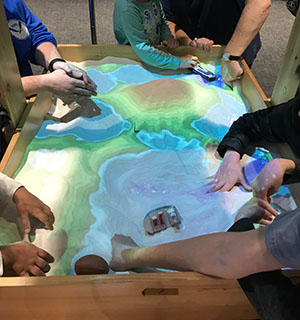 Children playing and learning about topographic maps with Coast Survey’s interactive 3D sandbox.