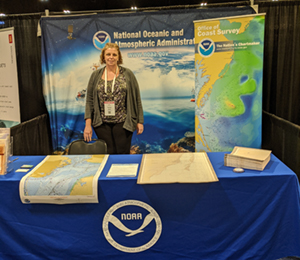 
	Lucy standing in front of the NOAA booth at Maritrends