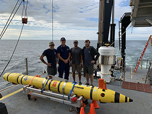 Rob Downs, Lt. John Kidd, Mike Annis, and Alex Ligon with the REMUS 600 AUV on NOAA Ship Okeanos Explorer.