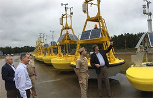 Helmut Portmann, director of the National Data Buoy Center, and other NDBC staff provide Rear Admiral Shepard Smith and Lt. Cmdr. Jason Mansour a tour of NDBC at Stennis.