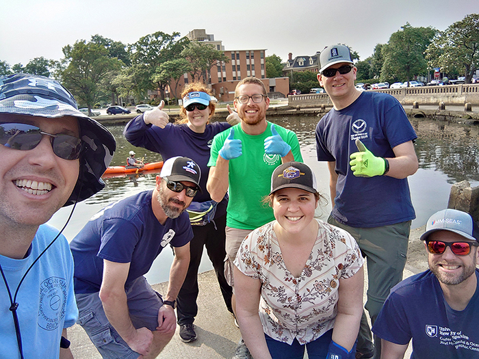 An image of participants during Clean the Bay Day 2023. From left to right: Matthew Wilson, Evan Robertson, Rita Bowker, Jonathan Haines, Amanda Finn, LCDR Bart Buesseler, and Clint Marcus.