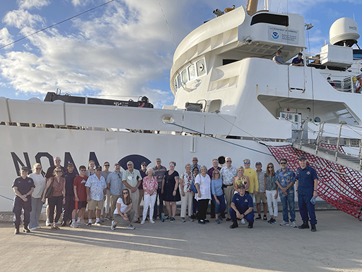 An image showing members of the Hydrographic Services Review Panel and meeting attendees posing for a picture prior to touring NOAA Ship Rainier with assistance from Rainier's officers and crew, in Pearl Harbor, Hawaii.