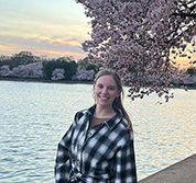 An image of Kayla Maurer standing with a cherry tree in the background.