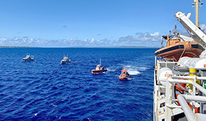 An image showing two hydrographic survey launches and two dive boats, waiting to be picked up at the end of the day by NOAA Ship Rainier.