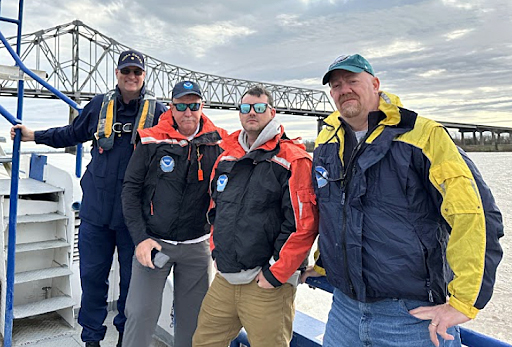 Coast Survey personnel pause for a picture on the Mississippi River. From left to right are: LCDR Mike Doig, Tim Osborn, Brian Akers, and Darren Wright.
