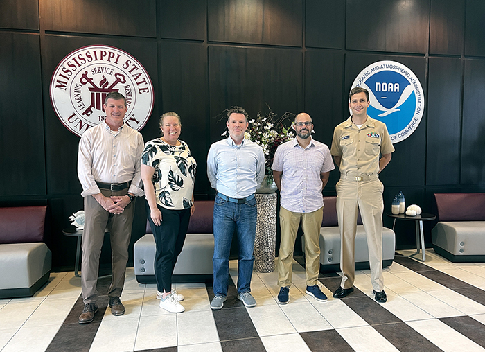 An image of in-person attendees in the meeting at Stennis Space Center. From left to right: Matt Borbash (Navy), Julia Powell, Grant Froelich, Mike Annis, and LTJG Collin McMillan from Coast Survey.