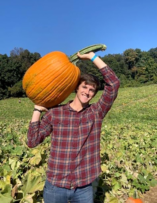 An image of Stephen Lafleur holding a pumpkin in a field.