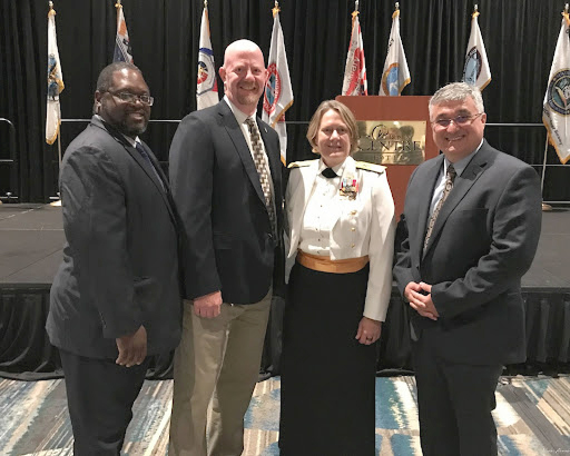 An image showing (left to right) Quentin Stubbs, Darren Wright, Admiral Linda Fagan, and Nicolás Alvarado at the U.S. Coast Guard Auxiliary National Conference in Orlando, Florida.