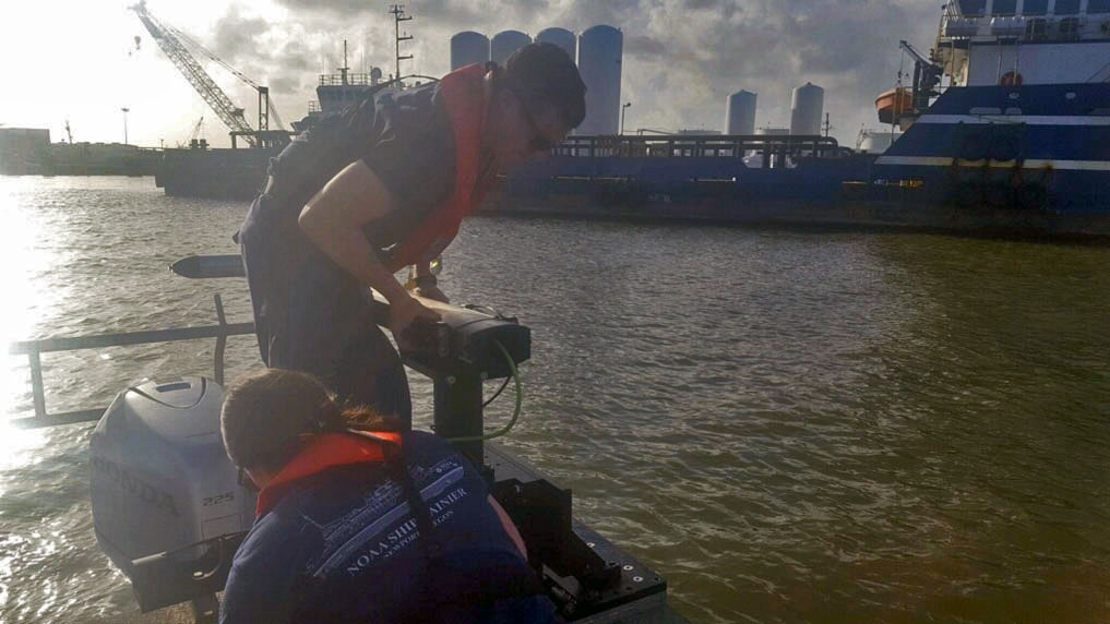 Lt. j.g. Patrick Lawler and Lt. j.g. Michelle Levano remove the side scan sonar from the water.