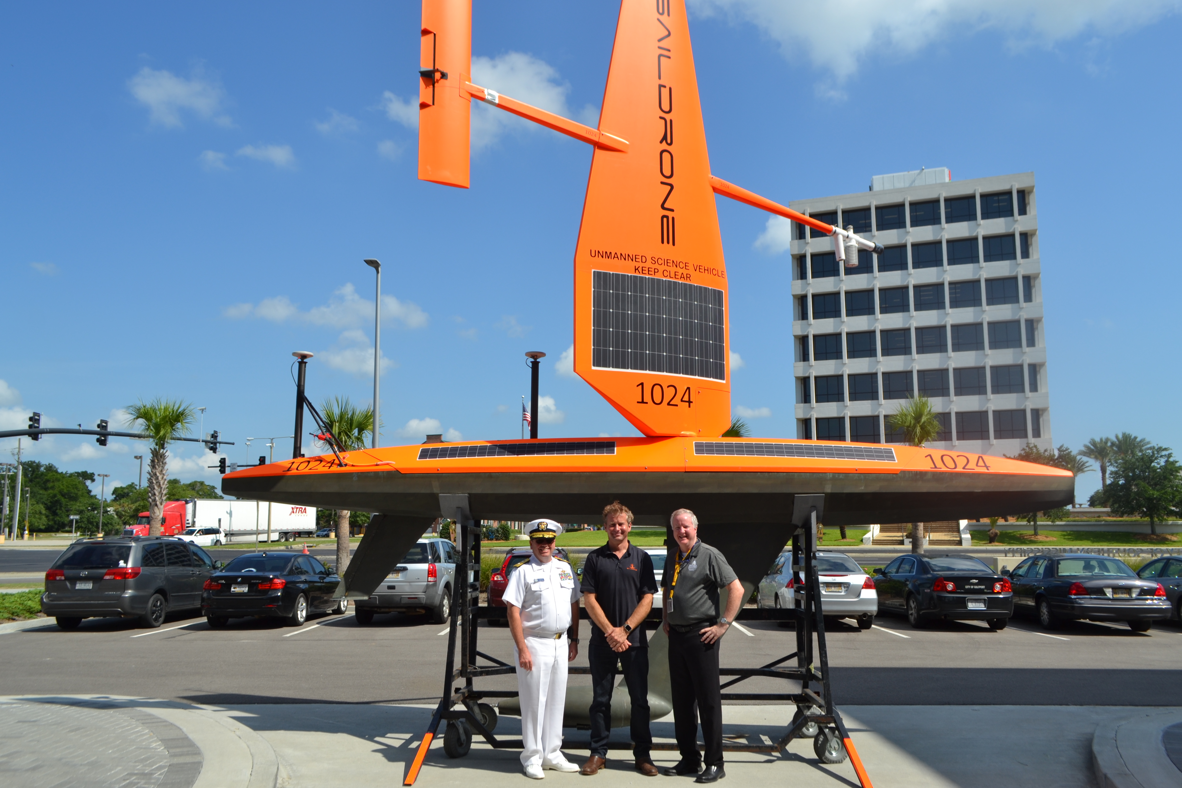 Rear Adm. Shep Smith, Richard Jenkins, and Brian Connon in front of a Saildrone.