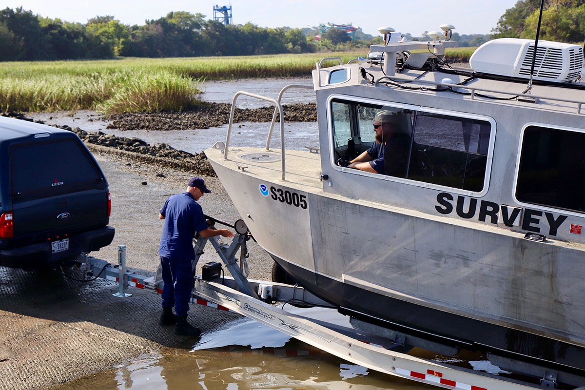 Lt. j.g. Colin Walker and Joshua Bergeron prepare to launch the team's response vessel into the Brunswick River.