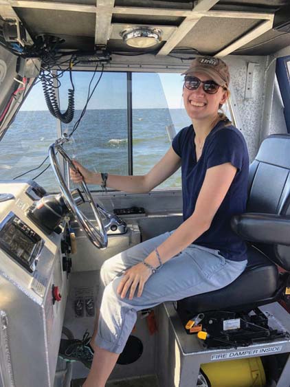 Natalie in the drivers seat of a survey launch.