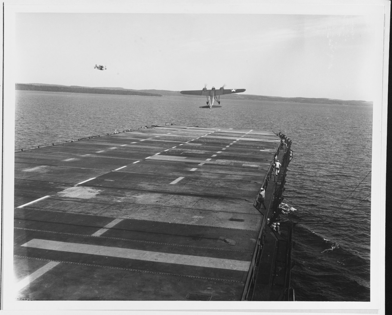 Launching a TDN-1 drone while steaming off Traverse City, Michigan, during flight tests on 10 August 1943. This plane has assumed an excessive nose-up attitude and is probably about to stall. Note the J2F amphibian flying off the ship's port bow, possibly acting as a drone control aircraft.