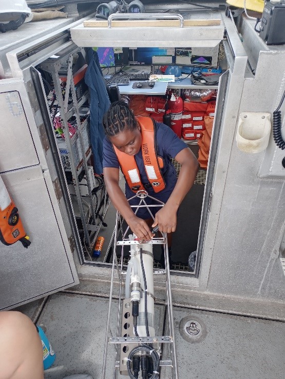 An image showing Sub-Lieutenant Mercy Modupe Ogungbamila transferring data from the conductivity, temperature, and depth sensor.