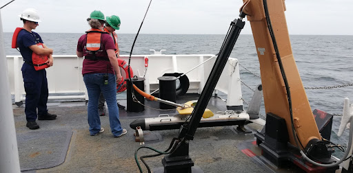 NOAA Ship Thomas Jefferson's crew preparing to deploy the side scan sonar in the water.