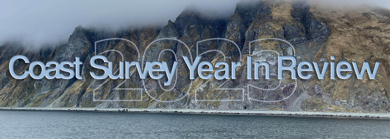 An image of a rocky coastline and low clouds with the title Coast Survey Year in Review, superimposed over it.